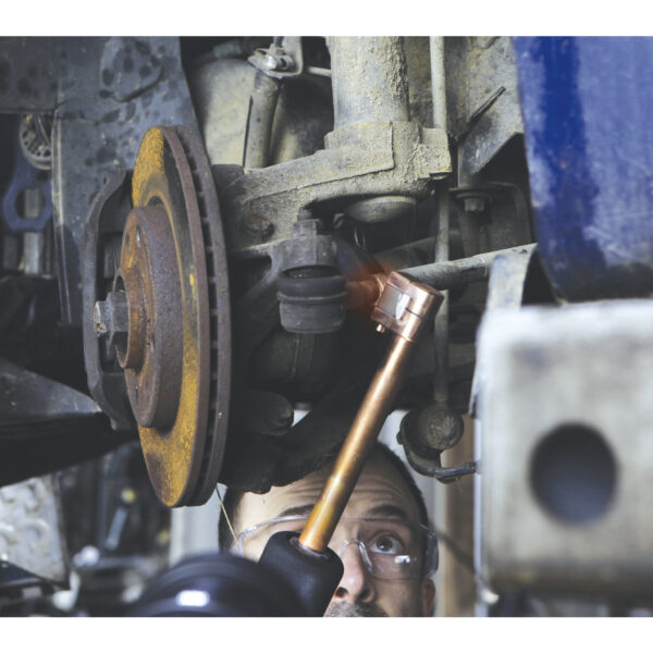 En mekaniker använder en Induktionsvärmare GYS Powerduction 37LG på en rostig bromsskiva under hjulnavet på ett fordon.