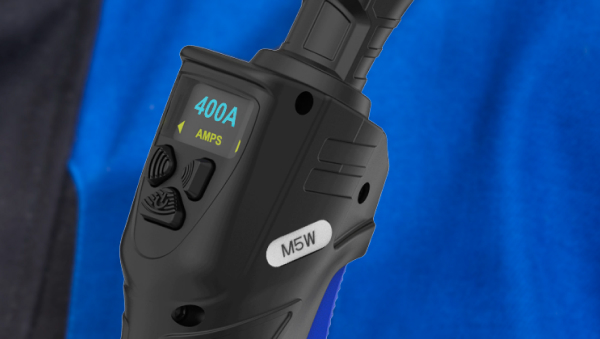 Närbild av en svart enhet märkt "M5W" som visar "400A AMPS" på en liten skärm, hållen av en person som bär en blå skjorta.